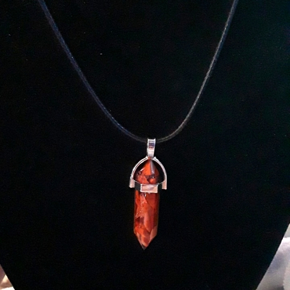 RESIN CRYSTAL WITH REDDISH BROWN CHIPS INSIDE AND CORD NEW